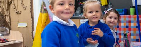 3 early years pupils pose for a photograph