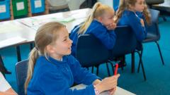 Pupils listening to their teacher in a classroom setting
