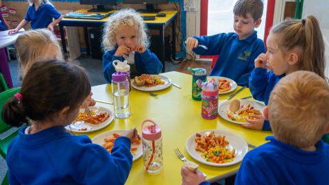 Group of early use pupils sat down for lunch